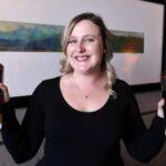 a woman holding a wine glass posing for the camera